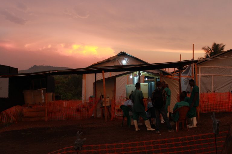 In this undated handout photo provided by Medecins Sans Frontieres, local staff and healthcare workers for Doctors Without Borders, exit an isolation ward in Guekedou, Guinea. For doctors and nurses fighting Ebola in West Africa, working in head-to-toe protective gear in muddy health clinics is often the least of their problems, as many also struggle to convince people they are there to stop Ebola, not spread it. (AP Photo/MSF)