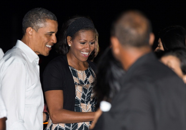 HONOLULU, HAWAII - JANUARY 5:  US President Barack Obama and First Lady Michelle Obama greet well wishers before boarding Air Force One at Joint Base Pearl Harbor-Hickam on January 5, 2013 in Honolulu, Hawaii. The president had to cut short his vacation to work in Washington on efforts to avert the recent fiscal cliff crisis and then returned to Hawaii to be with his family.  (Photo by Kent Nishimura - Pool/Getty Images)