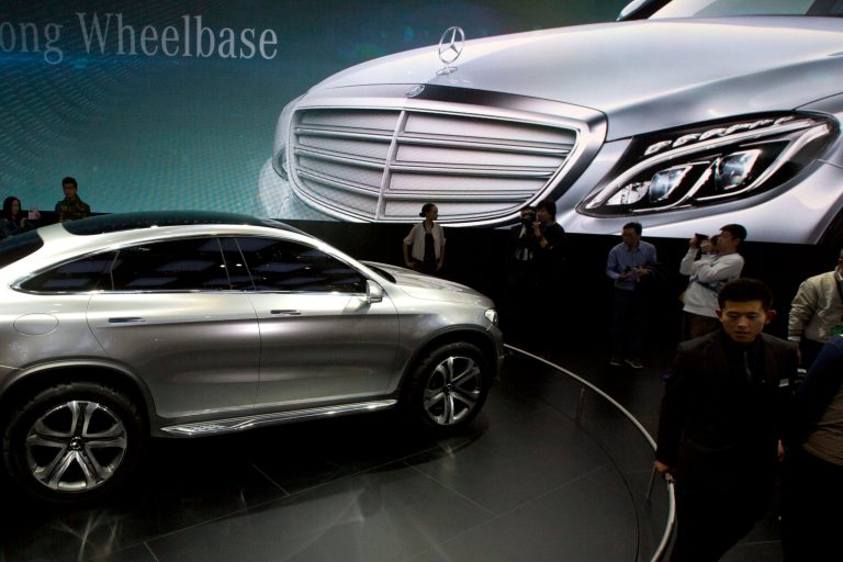 In this April 20, 2014 photo, visitors look at a Mercedes car at the company booth during the Auto China show in Beijing, China. Foreign companies in China feel increasingly targeted for unfair enforcement of anti-monopoly and other laws and might cut investment if conditions fail to improve, a business group said Tuesday, Sept. 2, 2014. (AP Photo/Ng Han Guan)