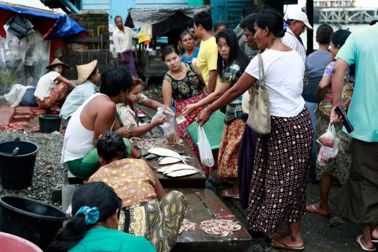   Locals buy fish from roadside vendors in Sittwe, the capital of Rakhine state in western Myanmar, where sectarian violence continues to impact the public, Wednesday, June 13, 2012. Heavy rain Wednesday brought an uneasy calm to western Myanmar after five days of deadly sectarian strife, though residents said they were too afraid to sleep at night and faced food shortages. (AP Photo/Khin Maung Win)  