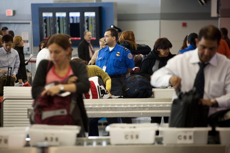 Passengers place their belongings in bins before passing through the passenger security checkpoint at John F. Kennedy International Airport's Terminal 8 on October 22, 2010 in the Queens borough of New York City. (Photo by Michael Nagle/Getty Images)