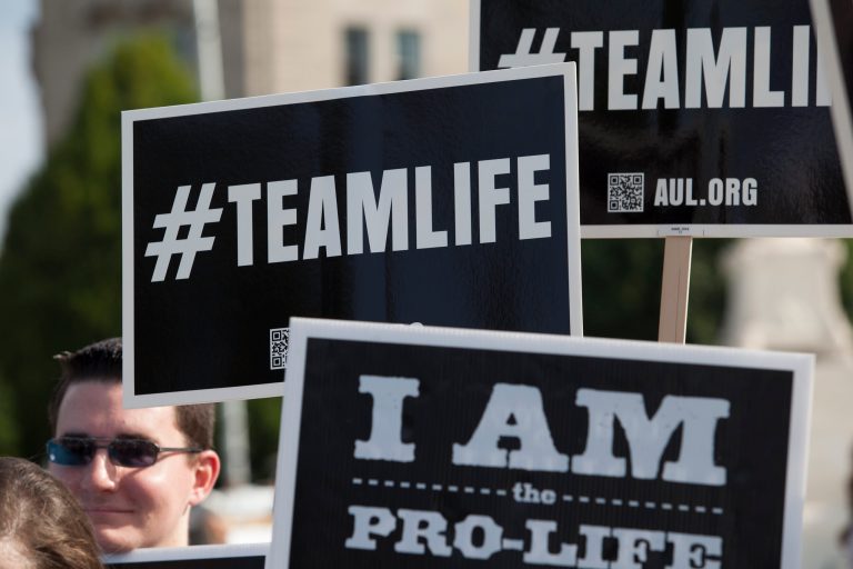 Demonstrators gathered out the U.S. Supreme Court on Monday, June 30th, 2014, to hear thecourt's decision on the Hobby Lobby case. (Examiner/Graeme Jennings)