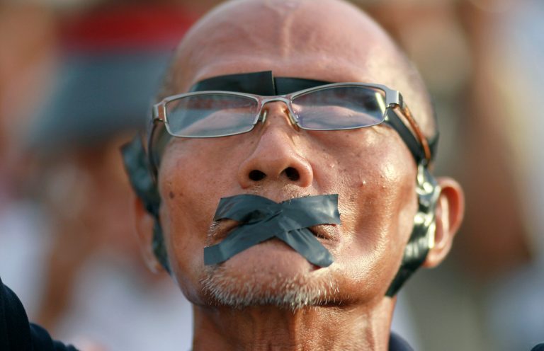 A protester displays how his rights were violated during an anti-coup demonstration at the Victory Monument in Bangkok, Thailand Wednesday, May 28, 2014.  Thailand's new military junta aired videos Wednesday on television stations nationwide showing some of the prominent political figures it has detained as part of an effort to convince the public that detainees in army custody are being treated well. (AP Photo/Wason Wanichakorn)