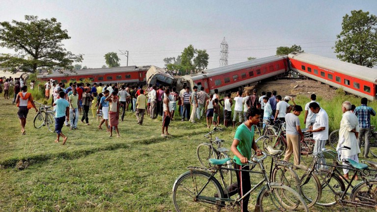 People gather around a passenger train that derailed near Chhapra town in Bihar, India, Wednesday, June 25, 2014. A passenger train derailed early Wednesday in the eastern Indian state of Bihar, killing at least four people and injuring eight others, officials said. The cause of the accident was not immediately known. (AP Photo)