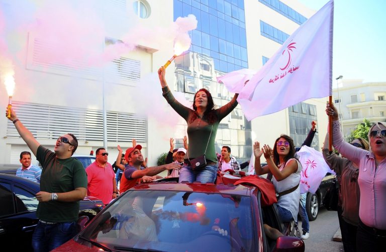 Supporters of Tunisian party Nida Tunis (Tunisia Calls) celebrate their victory in parliamentary elections in Tunis, Tuesday, Oct.28, 2014. Nida Tunis took around 35 percent of the seats of the parliament, giving it the right to present a prime minister and form a governing coalition. The Islamists trailed with just 25 percent of the seats. (AP Photo/Hassene Dridi)