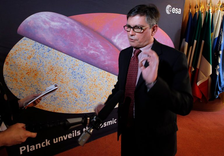 George Efstathiou, a European Space Agency astrophysicist speaks to The Associated Press after the press conference at ESA headquarters, in Paris, Thursday, March 21, 2013 in front of the most detailed map ever created of the cosmic microwave background acquired by ESA's Planck space telescope. Efstathiou, who announced the Planck satellite mapping on Thursday, says the findings also offer new specificity of the universe's composition. (AP Photo/Francois Mori)
