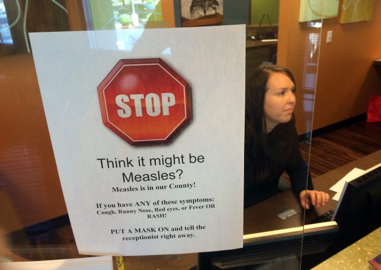 A sign warns of the dangers of measles in the reception area of a pediatrician's office in Scottsdale, Ariz., Saturday, Feb. 7, 2015. (AP Photo/Tom Stathis)