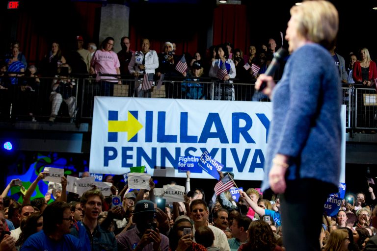 Protesters hold up signs as Democratic presidential candidate Hillary Clinton speaks at a campaign stop, Wednesday, April 20, 2016, in Philadelphia. (AP Photo/Matt Rourke)