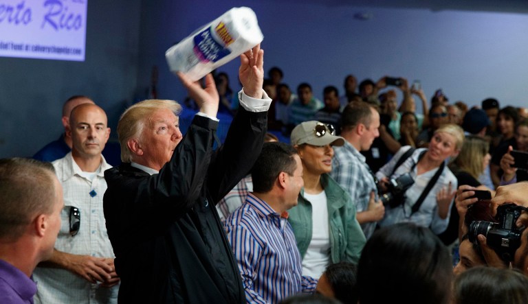 President Trump tosses paper towels into a crowd as he hands out supplies at Calvary Chapel in Guaynabo, Puerto Rico.