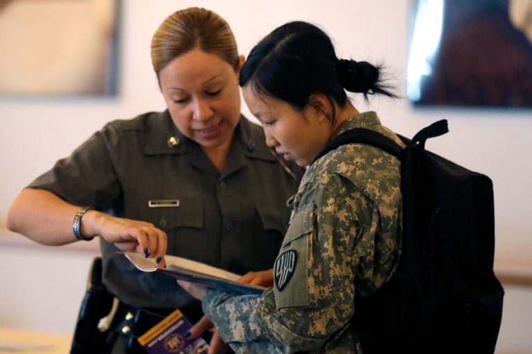 New York State Trooper Maxine Mendez, left, speaks to Xiaojiao Zuo, of Queens, about employment opportunities during a U.S. Chamber of Commerce Foundation Hiring Our Heroes jobs expo at Citi Field in New York. The Labor Department releases weekly jobless claims data on Thursday, July 9, 2015. (AP Photo/Mary Altaffer)