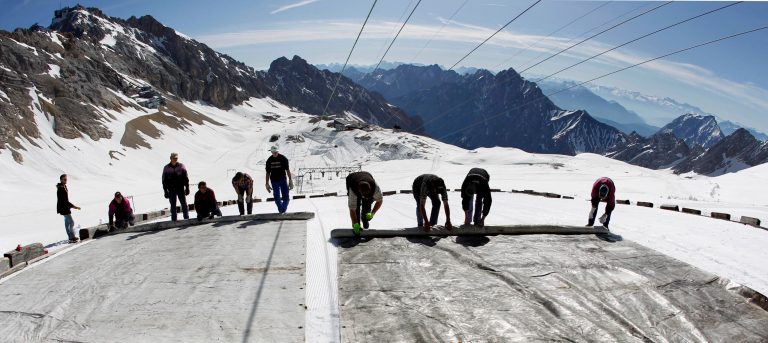 Workers roll out huge plastic mats on the glacier on the top of Germany highest mountain Zugspitze (2962 metres) near Garmisch-Partenkirchen, southern Germany, on Tuesday, May 10, 2011. The mats cover the glacier during the summer months to slow down its melting. (AP Photo/Matthias Schrader)