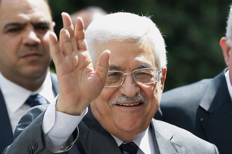Palestinian President Mahmoud Abbas waves to photographers as he arrives to attend an Arab foreign minister meeting at the Arab League headquarters in Cairo, Egypt, Sunday, Sept. 7, 2014. Abbas threatened to dissolve a new unity government if the Hamas militant group does not yield power in the Gaza Strip. (AP Photo/Hassan Ammar)