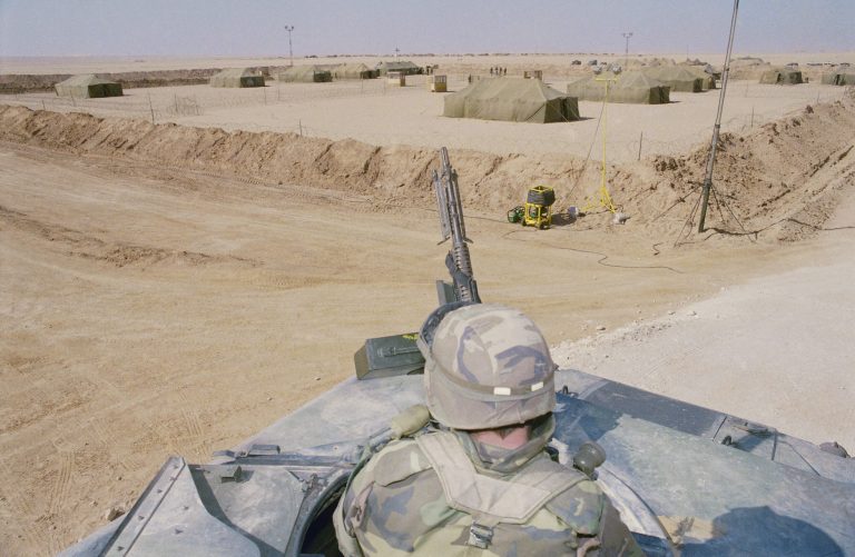 U.S. soldier on guard over 7th corps enemy prisoners of war holding area, February 1991, in central Saudi Arabia during Operation Desert Storm. (AP Photo/Jordan)