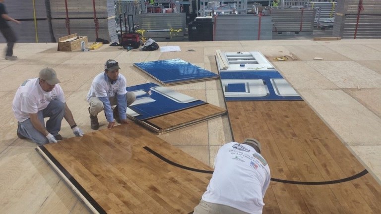 This undated photo provided by Connor Sports Flooring shows workers installing the hardwood floor being used at the Final Four in Arlington, Texas.  Connor has been manufacturing the floors for the Final Four for nearly a decade. It also makes 700 courts each year for the NBA, schools, gyms and colleges. (AP Photo/Connor Sports Flooring)