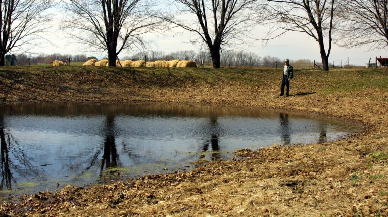 FILE - In this April 2, 2002, file photo, dairy farmer Paul Peter stands by his emergency pond near his house at Castleton-on-Hudson, N.Y. Industry groups and more than a dozen GOP senators are urging the Obama administration to reconsider a proposal by the EPA and the Army Corps of Engineers. The new rule seeks to clarify which waters or wetlands would trigger federal requirements, such as permitting and state water quality certification. Seasonal and rain-dependent streams, and wetlands near rivers and streams, would be covered; others would be considered on a case-by-case basis to determine if they play a significant role in the quality of downstream waters. Landowners and developers say the government has gone too far in regulating isolated ponds or marshes with no direct connection to navigable waterways. (AP Photo/Jim McKnight, File)