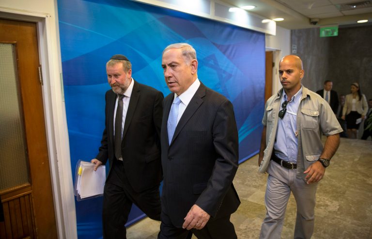 Israel's Prime Minister Benjamin Netanyahu, center, arrives to the weekly cabinet meeting at his office in Jerusalem, Sunday, June 22, 2014. Israel's military says troops have shot dead one Palestinian, and a Palestinian medical official says another was killed, as the army searches for three missing teens and looks to dismantle the Islamic militant group Hamas. Meanwhile the military says a civilian vehicle has exploded near the Syrian frontier in the Golan Heights, and that there are several casualties. (AP Photo/Baz Ratner, Pool)