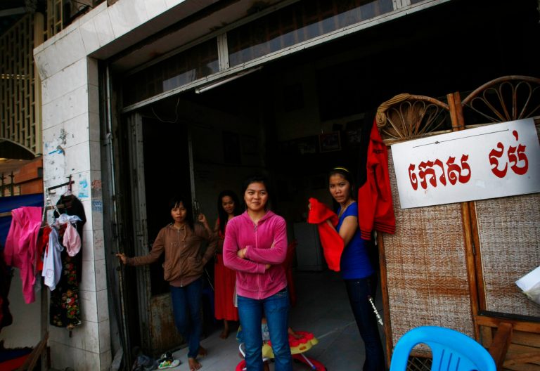 In this March 30, 2014 photo, Cambodian massagers wait for their costumers at a local massage parlor in Phnom Penh, Cambodia. Cambodia has enacted a regulation to protect nightclub hostesses and other adult entertainment workers under laws that protect other workers' labor rights. A joint statement from the labor and tourism ministries said Wednesday, Oct. 8, 2014 the regulation seeks to address problems faced by such workers, including poor occupational safety, violence, sexual harassment and excessive working hours. A sign at right reads: 
