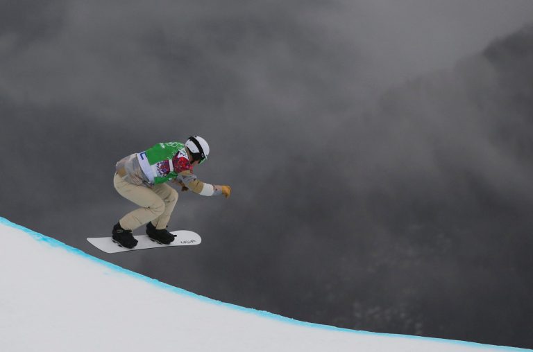 Nate Holland of the United States takes a drop during the third men's snowboard cross heat at the Rosa Khutor Extreme Park, at the 2014 Winter Olympics, Tuesday, Feb. 18, 2014, in Krasnaya Polyana, Russia. (AP Photo/Sergei Grits)