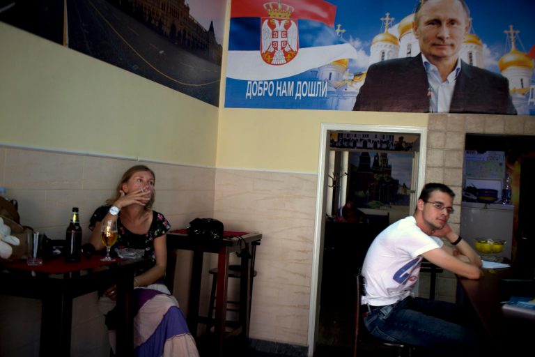 In this photo taken Tuesday, Aug. 5, 2014, a woman smokes as she has a drink at the 