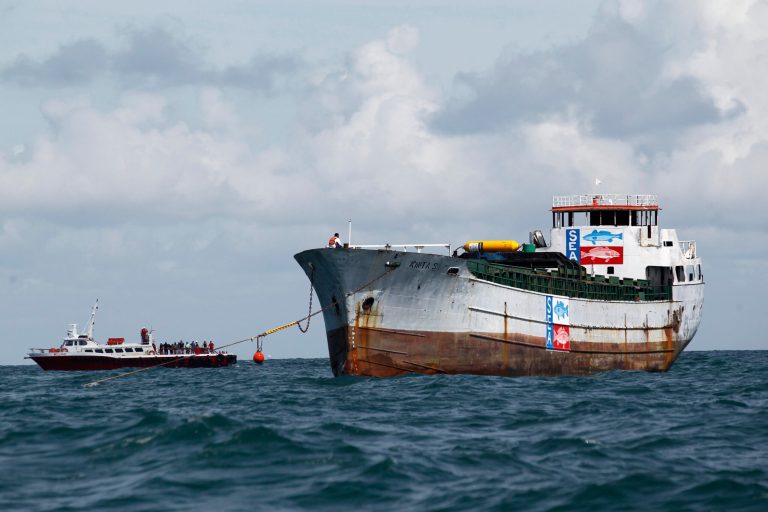 Onlookers wait from a nearby ship as the Kinta S cargo is positioned, Wednesday, Sept. 17, 2014 on the water to be sunk into the Gulf of Mexico to create an artificial reef off the Coast of Port Aransas, Texas. (AP Photo/Corpus Christi Caller-Times, Michael Zamora)