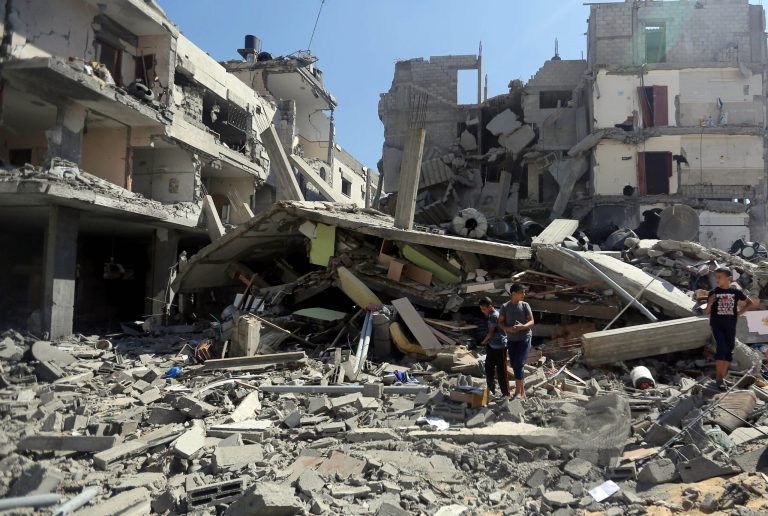 Palestinians inspect the rubble of a building after it was hit by an Israeli missile strike in Gaza City, Friday, July 11, 2014. Israel launched the Gaza offensive to stop incessant rocket fire that erupted after three Israeli teenagers were kidnapped and killed in the West Bank and a Palestinian teenager was abducted and burned to death in an apparent reprisal attack. The military says it has hit more than 1,100 targets already, mostly what it identified as rocket-launching sites, bombarding the territory on average every five minutes.(AP Photo/Hatem Moussa)
