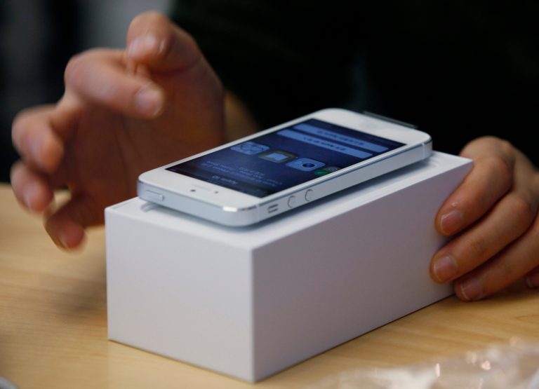   FILE - In this Friday, Sept. 21, 2012, file photo a customer tests the new iPhone 5 at the Apple store in Hong Kong. T-Mobile will likely start carrying the iPhone next year after its parent company, Deutsche Telekom, said it has reached a new deal with Apple. T-Mobile USA had been the lone iPhone-less carrier among the four national wireless companies in the U.S. Although it has been possible to use iPhones on T-Mobile networks, customers had to provide the phones themselves. The phones also work at much slower speeds, though T-Mobile has been reshuffling its network to match or exceed AT&T's data speeds. (AP Photo/Kin Cheung, File)  