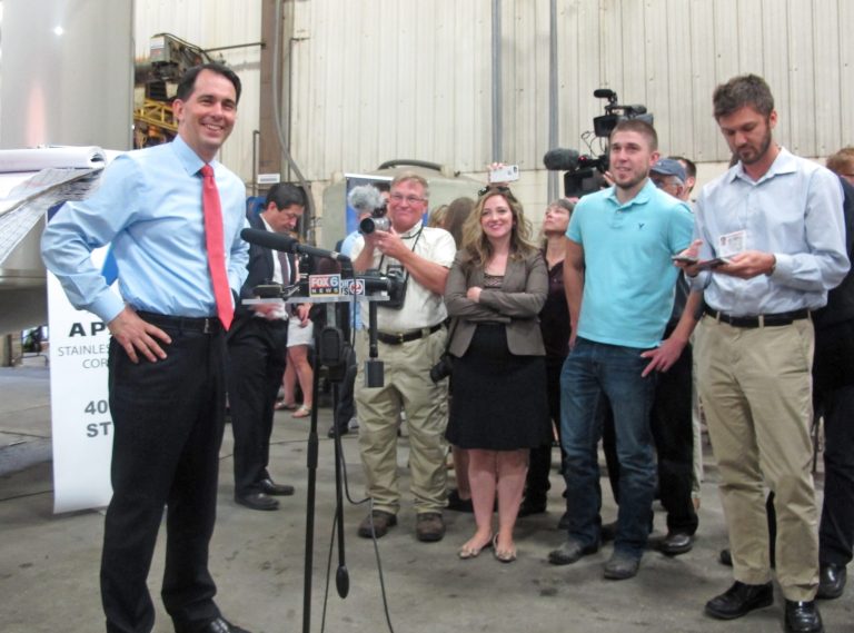 Wisconsin Gov. Scott Walker, left, takes reporters' questions for the first time since dropping out of the presidential race on Friday, Sept. 25, 2015, in Beaver Dam, Wis. Walker doesn't want to endorse any of his fellow Republicans who remain in the race for president just yet. (AP Photo/Scott Bauer)