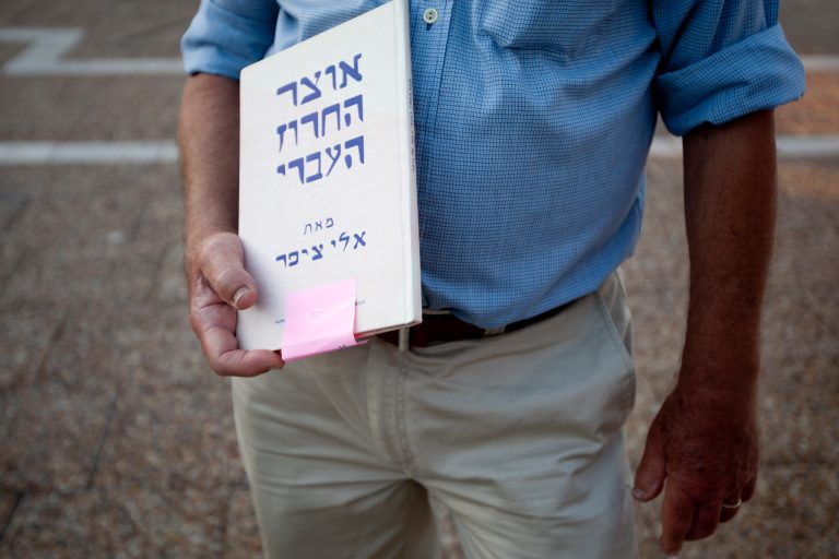   In this Wednesday, June 13, 2012 photo, Israeli author Eli Tziper holds a copy of his book 