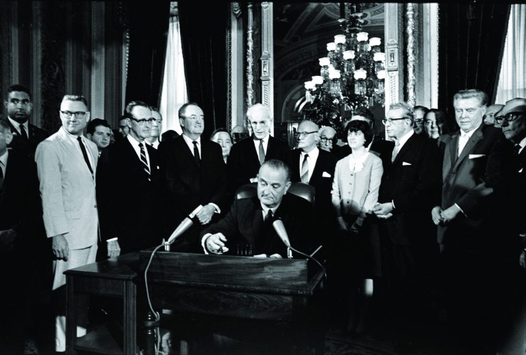 FILE - In this Aug. 6, 1965, photo, President Lyndon Baines Johnson signs the Voting Rights Act of 1965 in a ceremony in the President's Room near the Senate Chambers on Capitol Hill in Washington. Three years ago, the Supreme Court warned there could be constitutional problems with a landmark civil rights law that has opened voting booths to millions of African-Americans. Now, opponents of a key part of the Voting Rights Act are asking the high court to finish that provision off. Surrounding the president from left directly above his right hand, Vice President Hubert Humphrey; House Speaker John McCormack; Rep. Emanuel Celler, D-N.Y.; first daughter Luci Johnson; and Sen. Everett Dirksen, R-Ill. Behind Humphrey is House Majority Leader Carl Albert of Oklahoma; and behind Celler is Sen. Carl Hayden, D-Ariz. (AP Photo)