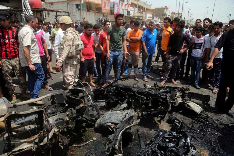 Security forces and citizens inspect the scene after a car bomb explosion at a crowded outdoor market in the Iraqi capital's eastern district of Sadr City, Iraq, Wednesday. (AP Photo/ Khalid Mohammed)