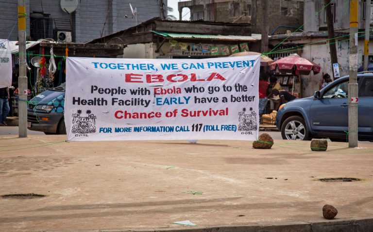 A banner encouraging people suffering from Ebola to go immediately to a health center for treatment is seen on a sidewalk in the city of  Freetown, Sierra Leone, Thursday, Aug. 7, 2014. While the Ebola virus outbreak has now reached four countries, Liberia and Sierra Leone account for more than 60 percent of the deaths, according to the World Health Organization. The outbreak that emerged in March has claimed at least 932 lives. (AP Photo/Michael Duff)