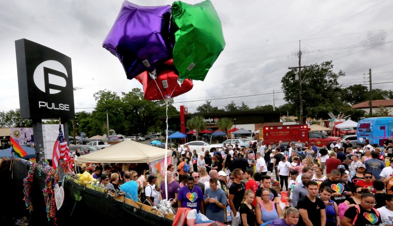 Church bells tolled 49 times, a giant rainbow flag hung from a county government building and the names of the victims of the Pulse nightclub attack were read aloud at various ceremonies Monday as people in Orlando and beyond remembered the worst mass shooting in modern U.S. history. (Joe Burbank/Orlando Sentinel via AP)