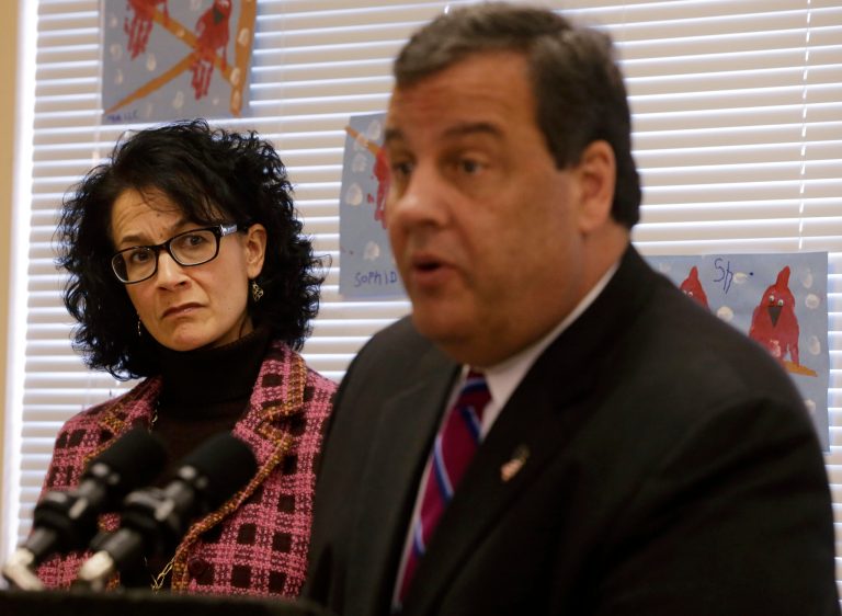 New Jersey Department of Human Services Commissioner Jennifer Velez, left, listens as Gov. Chris Christie addresses a gathering, Wednesday, Feb. 12, 2014, in Toms River, N.J., that included some victims still out of their homes or businesses as a result of Superstorm Sandy in October 2012. Christie said a Superstorm Sandy aid program that provides families with temporary help with living expenses has reached more than 7,000 storm victims in the last three-and-a-half months. Since the federally funded program was announced in late October, Christie said just over $11 million has been distributed, which is about 20 percent of the total available money. (AP Photo/Mel Evans)