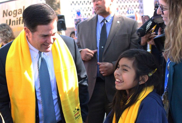 Arizona Gov. Doug Ducey talks with a 6th grader at a school choice event. Ducey signed 