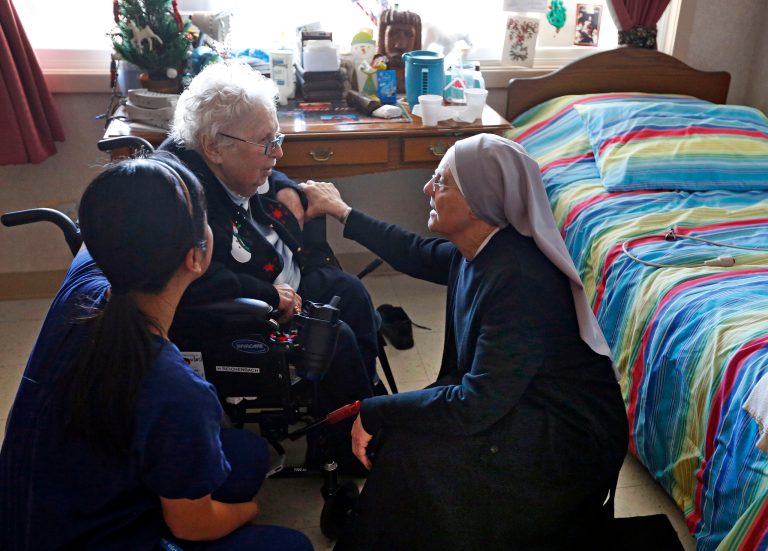 Mother Patricia Mary, right, and nurse Friary Nguyen visit 99-year-old resident Helen Reichenbach in her room at the Mullen Home for the Aged, run by Little Sisters of the Poor, in Denver, Colo., on Jan. 2. (AP Photo/Brennan Linsley, File)