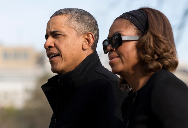 President Barack Obama and first lady Michelle Obama walk across the South Lawn of the White House from Marine One, Sunday, March 9, 2014, in Washington, as they arrive from Florida. (AP Photo/Carolyn Kaster)