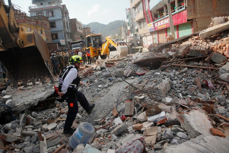 A rescue worker from USAID inspects the site of a building that collapsed in an earthquake in Kathmandu, Nepal, Tuesday, May 12, 2015. (AP Photo/Niranjan Shrestha)