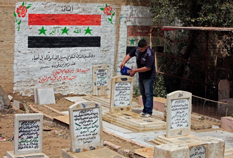 In this Saturday, April 6, 2013 photo, an Iraqi man pours water onto the grave of his father, who was killed during a fight with U.S. forces, at a cemetery in Baghdad, Iraq. Ten years ago, a statue fell in Paradise Square. Joyful Iraqis helped by a U.S. Army tank retriever pulled down their longtime dictator, cast as 16 feet of bronze. The scene broadcast live worldwide became an icon for a war, a symbol of final victory over Saddam Hussein. But for the people of Baghdad, it was only the beginning. The toppling of the statue on April 9, 2003, remains a potent symbol that has divided Iraqis ever since. (AP Photo/ Karim Kadim)