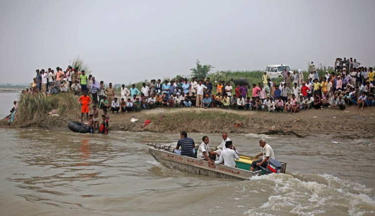 A boat crowded with construction workers capsized in the Yamuna River in northern India early Thursday and more than a dozen people have drowned, officials said. (AP Photo/Altaf Qadri)
