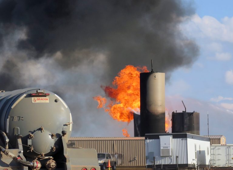 In this Monday, July 7, 2014 file photo, a saltwater disposal facility burns after it was struck by lightning, near Alexander, N.D.  Three massive fires since the beginning of June have highlighted the threat lightning poses in the North Dakota oil patch, and in each case it was tanks that store the toxic saltwater associated with drilling, not the oil wells or drilling rigs, that were to blame.  (AP Photo/Josh Wood, File)