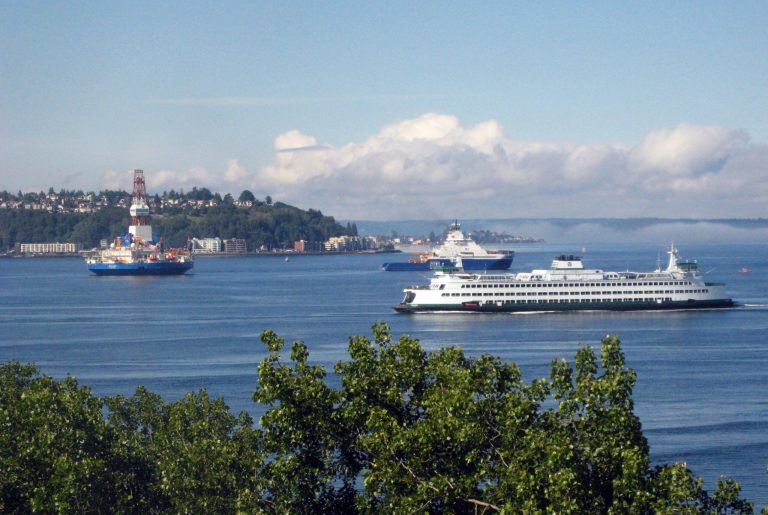 Ships bringing oil drilling equipment to Alaska, left, pass through Seattle's Elliott Bay on Wednesday, June 27, 2012, as a Washington State Ferry passes on its way into Seattle. (AP Photo/Donna Gordon Blankinship)