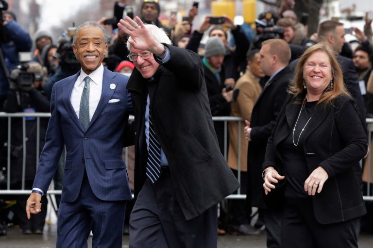 The Rev. Al Sharpton, left, escorts Democratic presidential candidate Sen. Bernie Sanders, I-Vt. and his wife, Jane O'Meara Sanders, as they arrive for a breakfast meeting at Sylvia's Restaurant, Wednesday. (AP Photo/Richard Drew)