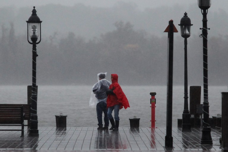 People brave driving wind and rain along the pier in Old Town Alexandria on Monday. (Graeme Jennings/Examiner)