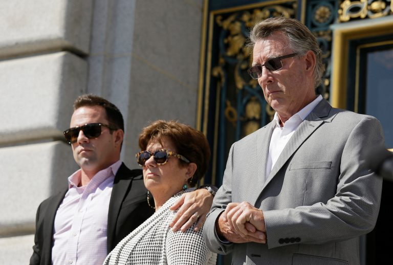 File - In this Sept. 1, 2015 file photo, from left, Brad Steinle, Liz Sullivan and Jim Steinle, the brother, mother and father of Kate Steinle who was shot to death on a pier, listen to their attorneys speak during a news conference on the steps of City Hall in San Francisco. The parents of a woman killed on a San Francisco pier by a man in the country illegally is suing the city and two federal agencies that they say contributed to her death. Kate Steinle's parents filed the wrongful-death lawsuit Friday, May 27, 2016. It accuses the San Francisco Sheriff's Department of failing to notify federal immigration officials that it was releasing Juan Francisco Lopez-Sanchez from jail. (AP Photo/Eric Risberg, File)