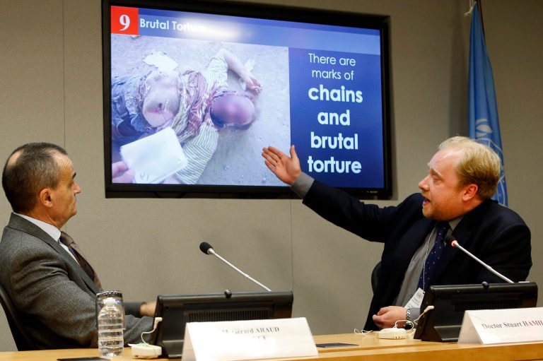 EDS NOTE: GRAPHIC CONTENT - Forensic pathologist Dr. Stuart Hamilton, right, presents one of the photos in a series of what is reported to be photographic evidence of torture in Syria as Gerard Araud, France's ambassador to the United Nations, looks on during a news conference at U.N. headquarters following a closed Security Council meeting on Tuesday, April 15, 2014. Ambassador Araud said a pall of silence lingered after the council members viewed the ghastly photographs of dead Syrian civil war victims, then questions slowly began about the credibility of the slides of the dead, who offer mute testimony to the savagery of a Syrian civil war in which more than 150,000 have died. (AP Photo/Jason DeCrow)