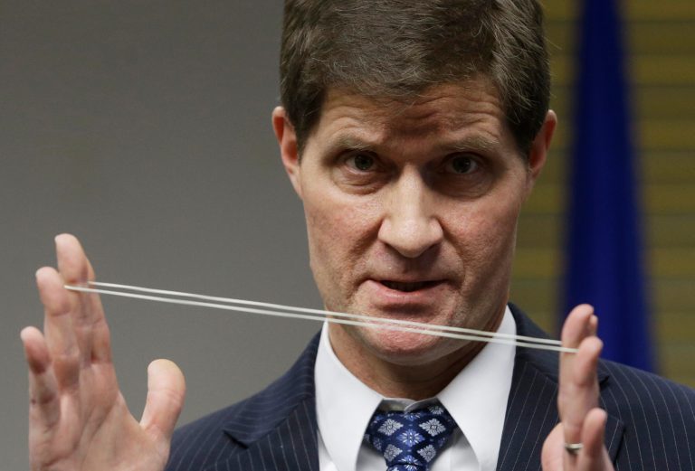 Milwaukee County District Attorney John Chisholm demonstrates bullet trajectory at news conference Monday, Dec. 22, 2014, in Milwaukee. (AP Photo/Morry Gash)