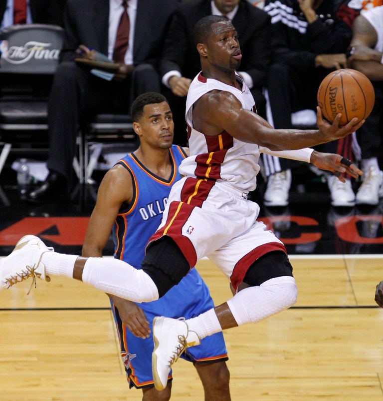   Miami Heat shooting guard Dwyane Wade (3) gets past Oklahoma City Thunder shooting guard Thabo Sefolosha (2) of Switzerland to shoot the ball during the first half at Game 3 of the NBA Finals basketball series, Sunday, June 17, 2012, in Miami. (AP Photo/Wilfredo Lee)  