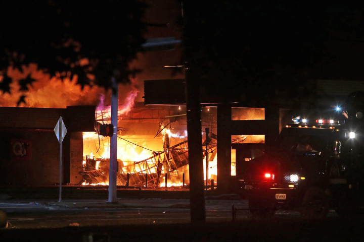 A convenience store was set on fire after a candlelight vigil for an unarmed 18-year-old shot and killed by a policeman in Ferguson, Mo. AP Photo