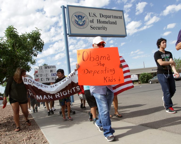 Marchers held signs as they made their way to Department of Homeland Security offices, protesting immigration policies Thursday, July 10, 2014, in El Paso, Texas. (AP Photo/El Paso Times, Victor Calzada)