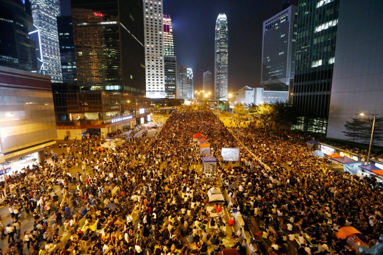 Pro-democracy protesters attend a rally in the occupied areas outside government headquarters in Hong Kong's Admiralty, Friday, Oct. 10, 2014. Hundreds of thousands of people are pouring into a main road in Hong Kong to show support for a pro-democracy protest after the government called off talks with student leaders. (AP Photo/Kin Cheung)